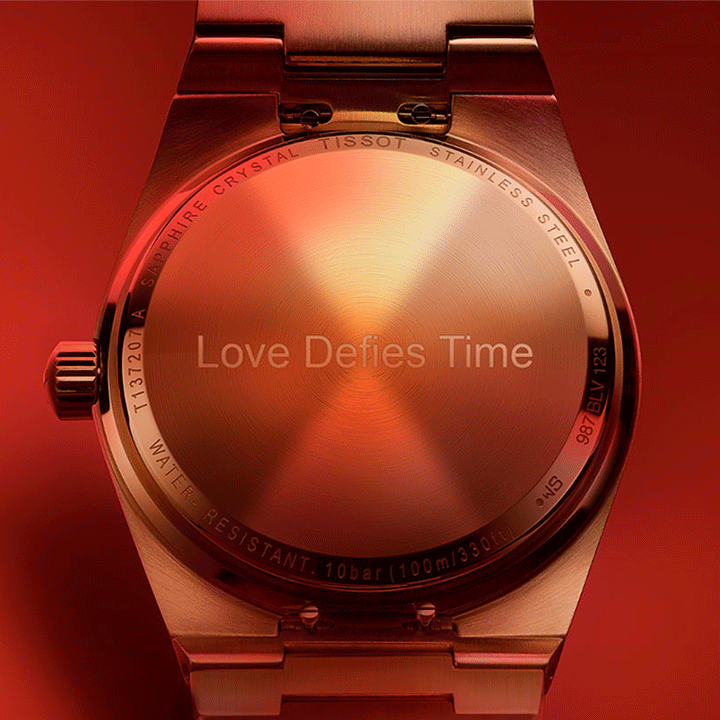 Case back of a Tissot PRX engraved with "Love Defies Time"